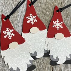 two red and white christmas gnomes with snowflakes on their heads hanging from strings