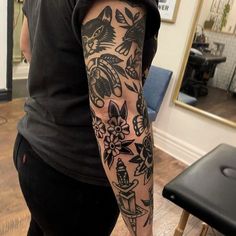 a woman with a tattoo on her arm is standing in front of a mirror and looking at the camera