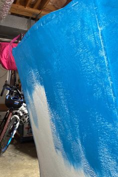 there is a blue surfboard in the garage