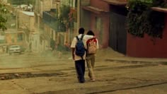 two people walking down the street with backpacks on