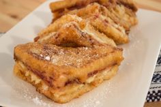 two pieces of french toast on a white plate with sugar sprinkled on top