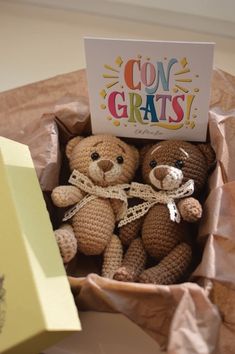 two teddy bears in a box with congratulations card