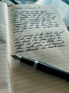 an open notebook with writing on it and a pen resting on the top of it