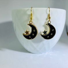 "Gold Plated Enameled Moon & Star Charm Earrings Material: Zinc Based Alloy (Lead and Nickel Safe) Size: 24mm x17mm (1\" x 5/8\") Color: Gold Plated/Black Nickel free ear-wire  Join my facebook group to see when new items are available- https://www.facebook.com/radcrafty Instagram- https://www.instagram.com/radberry1/" Black Moon Charm Jewelry For Party, Black Jewelry With Moon Charm For Party, Space-themed Gold Jewelry Gift, Black Metal Moon Shaped Jewelry, Black Metal Moon-shaped Jewelry, Black Crescent Metal Jewelry, Black Metal Crescent Jewelry, Black Enamel Earrings, Pierced, Handmade Black Enamel Earrings