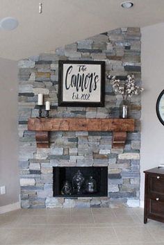 a living room with a stone fireplace and sign on the wall above it's mantle