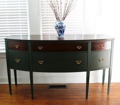 a table with two drawers and a vase sitting on it's top, in front of a window