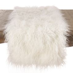 a white furry pillow sitting on top of a wooden post