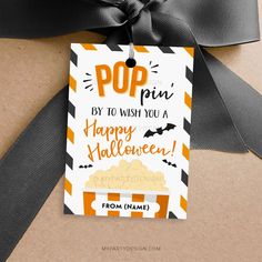 an orange and black striped gift tag with the words pop by to wish you a happy halloween