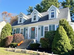 a white house with blue shutters and trees