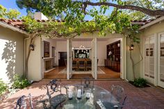 an outdoor dining area with glass table and chairs