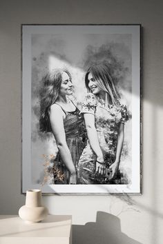 two women standing next to each other in front of a black and white photo on the wall