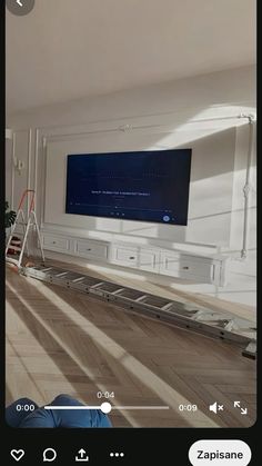 a person is sitting on the floor in front of a flat screen tv