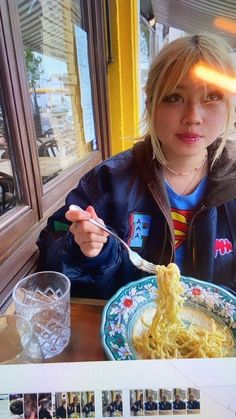 a woman sitting at a table eating spaghetti from a plate with the word yummy written on it