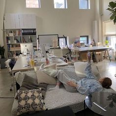 a person laying on top of a couch in a living room next to a table