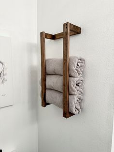 a towel rack is mounted on the wall above a toilet in a bathroom with white walls