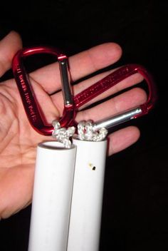 two lighters in the palm of a person's hand, one is red and the other is white