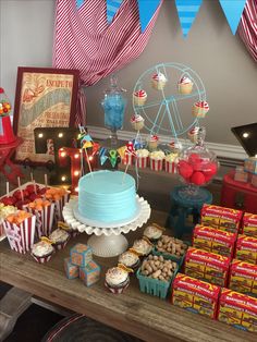 a table topped with lots of cakes and cupcakes next to a ferris wheel