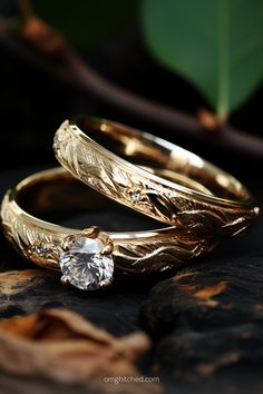 two gold wedding rings sitting on top of each other