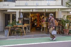 a man walking down the street in front of a store