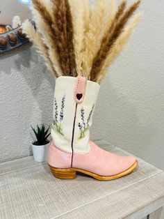 a pair of pink boots with feathers sticking out of them on top of a table