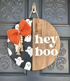 a door hanger that says hey boo on it with ghost decorations and a bow