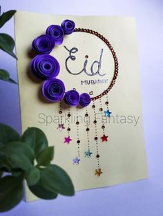 a greeting card with purple paper flowers and beads