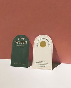 two bottles of cologne sitting next to each other on a white countertop against a pink wall