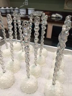 a group of crystal candles sitting on top of a white table next to each other