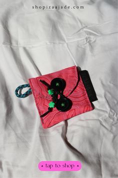 a pink and black purse sitting on top of a white bed with the words tips to shop