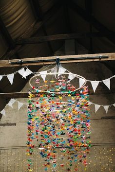 a wind chime hanging in the middle of a room with bunting and flags