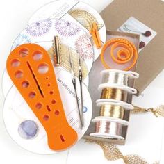 sewing supplies including scissors, thread and spools on a white table with gold ribbon