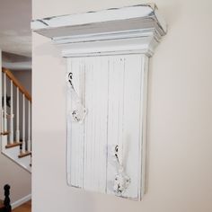 an old white cabinet is hanging on the wall