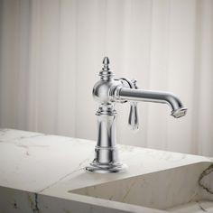 a chrome faucet sitting on top of a white marble counter next to a window