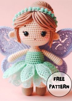 a crocheted little fairy doll with green and purple wings, standing on a pink background