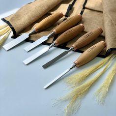 five knives are lined up next to each other on a table with burlock