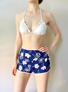 *A California Poppy by Lanz beach shorts from the 1960s *Dolphin shorts style with brief-style lining *50% polyester/50% cotton This fun pair of vintage beach shorts has a bright blue and white tropical print. The white brief-style lining has elastic at the bottoms. The shorts zip up the back and have a button loop at the top. These are great for strolling along the boardwalk or wearing over a swimsuit! Label: A California Poppy by Lanz, Cut 55-91, Style 8437, Made in U.S.A. Size: Small, tagged size 10 * Measurements * Waist: 26" Hips: 35" Length (top to crotch): 25" Material has no stretch. (Bust, waist and hip measurements are approximate, taken from seam to seam with garment laying flat and doubled. Model typically wears size small in swimwear.) Condition: Good vintage condition. A hori Summer Swimwear With Built-in Shorts For Summer Outings, Beachy Shorts For Summer, Beach Party Shorts With Built-in Liner For Beach Season, Summer Shorts For Beach, Beachy Summer Shorts, Beachy Cotton Shorts For Beach Party, Beachy Short Bottoms For Beach Party, Beachy Shorts For Beach Party Season, Beachy High-waisted Shorts For Beach Season