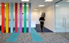 a man is standing in an office with colorful stripes on the wall