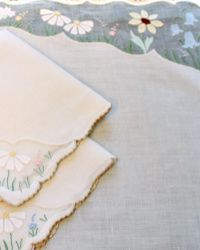 two white napkins with flower designs on them