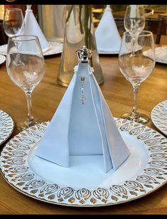 the table is set with white plates and napkins, silverware and wine glasses