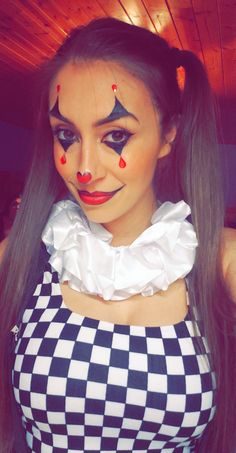 a woman with makeup on her face and checkered dress, posing for the camera