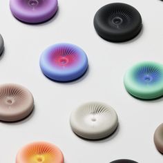 an array of different colored buttons on a white surface