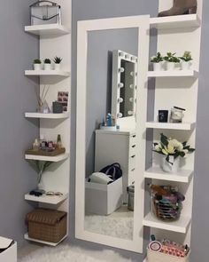 a mirror sitting on top of a white shelf next to a wall filled with shelves