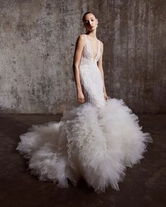 a woman in a white dress is standing with her back to the camera and she has long, feathery skirt