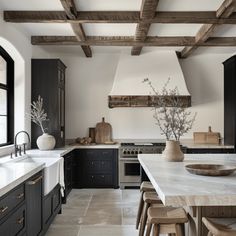 a kitchen with black cabinets and white counter tops, an island in the middle is surrounded by stools