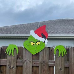 the grin face has been painted on this wooden fence and is wearing a santa hat