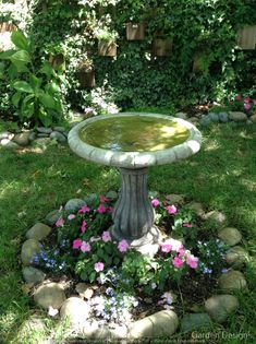 a bird bath sitting on top of a lush green field