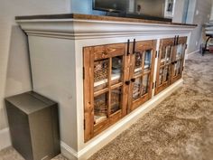 an entertainment center made out of wood and glass doors