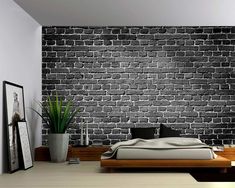 a bedroom with a brick wall in the background and a plant on the floor next to it