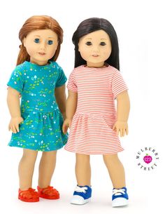 two dolls are standing next to each other