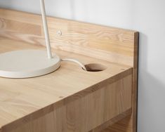 an electronic device is plugged into the wall next to a wooden counter top with a white light on it